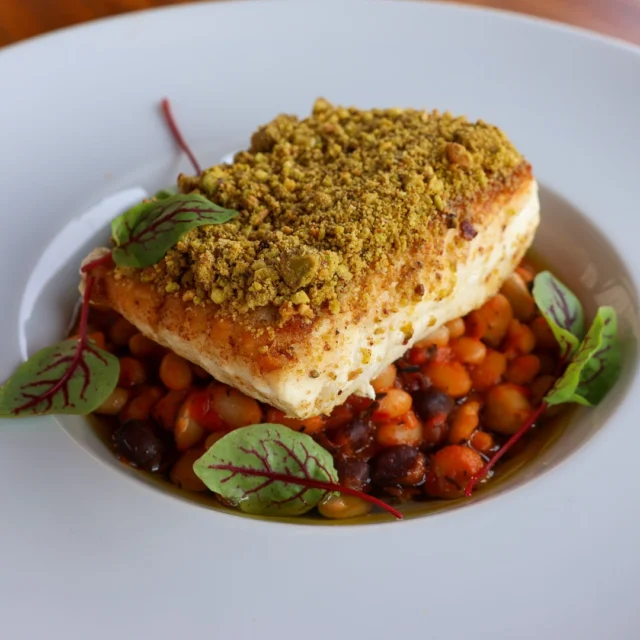 Enjoy our delicious Pistachio-Crusted Halibut recipe atop a hearty Bean Cassoulet featuring a rich blend of black beans, chickpeas and roasted red peppers.Coated in a fragrant pistachio-cinnamon crust, the tender halibut pairs perfectly with the flavourful, herb-infused bean medley. Garnished with fresh parsley and cilantro, this dish promises a delightful blend of textures and tastes. Link in bio for recipe!